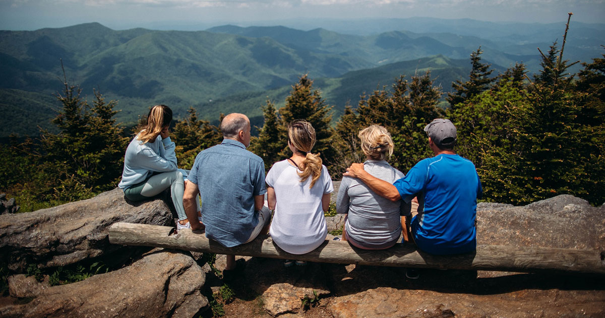 山を見下ろす岩の上に座っている家族5人