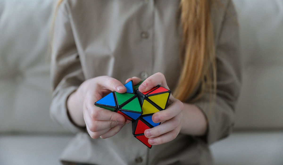 三角錐の立体パズルを解く女性